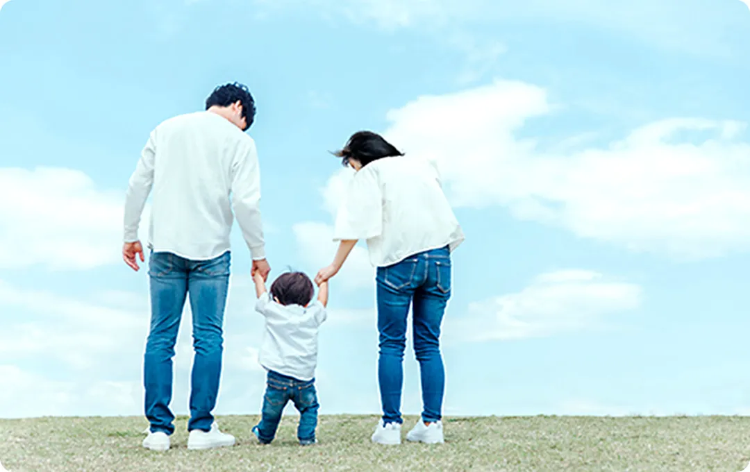 左に夫・中心に子ども・右に妻の3人が手を繋いでいる後ろ姿