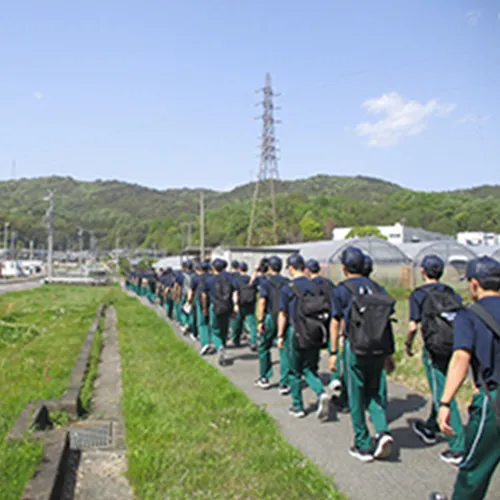 田んぼ道を2列になって歩いている様子