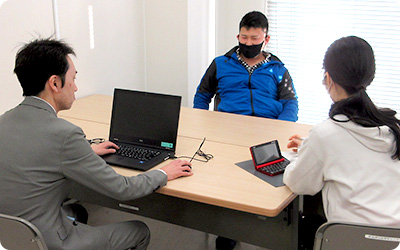 3人がテーブルに座り、パソコンで何かしている様子